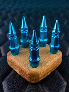 Close-up of blue metallic cap tips on a valve, spiked shape, against a black  Stock Photos