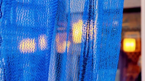 Close-Up of Blue Netting with Blurred Warm Lights in Background Stock Footage 307416825