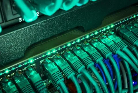 Close up of blue network cables connected to switch glowing in the dark Stock Photos