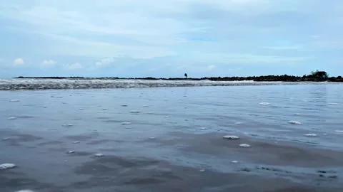 Close-up of blue Ocean Waves on a Sandy Beach with blue sky.  4K Video stock 301449876