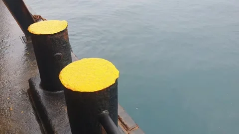 Close up of blue ocean waves swaying gently with massive barge and boulder Stock Footage 346572311