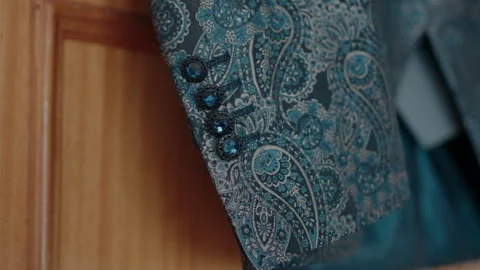 Close-up of a blue paisley patterned suit sleeve with detailed buttons. Stock Footage 278879743