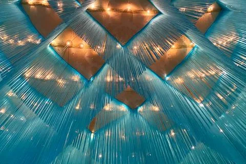 Close up of a blue patterned ceiling with many light bulbs. Stock Photos