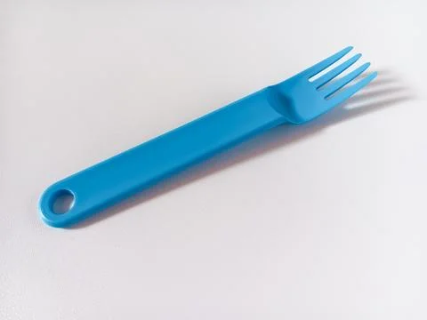 Close up of blue plastic fork isolated on white background. Stock Photos
