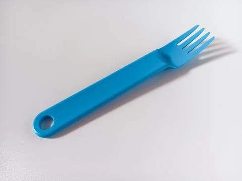 Close up of blue plastic fork isolated on white background. Stock Photos