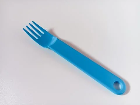 Close up of blue plastic fork isolated on white background. Stock Photos