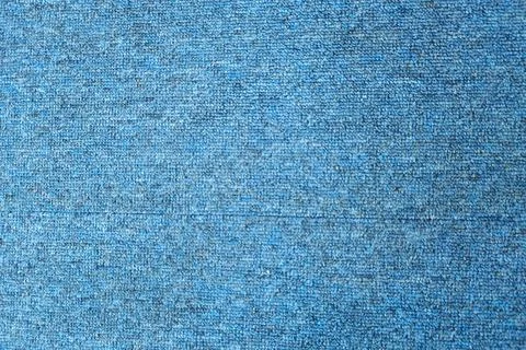 A close-up of a blue textured fabric with a subtle, speckled pattern. Stock Photos
