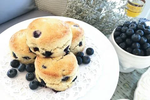 Close-up blueberry scones and some blueberries on the rattan table. Stock Photos
