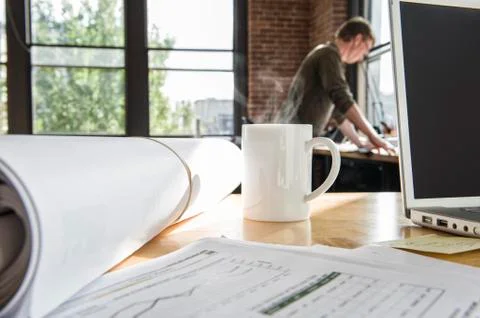 Close-up of blueprints on a desk top in a creative office. Stock Photos