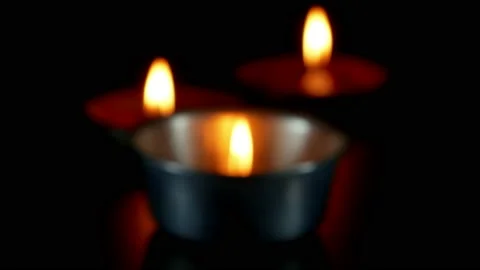 Close up blured candles flame on black shiny paper on dark Background. Stock Footage 151178717