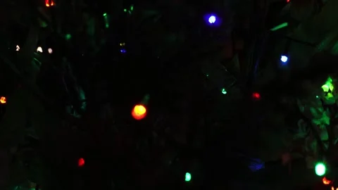 Close-up of blurred Christmas lights in red green and blue hues against a dark Stock Footage 345182190