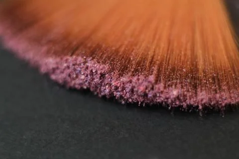 Close up. blurred image of a brush smears grains of powder on a black background Stock Photos