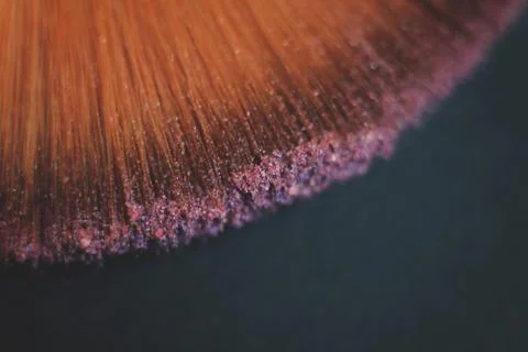 Close up. blurred image of a brush smears grains of powder on a black background Stock Photos