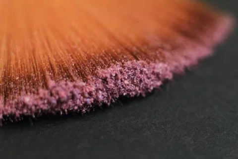 Close up. blurred image of a brush smears grains of powder on a black background Stock Photos