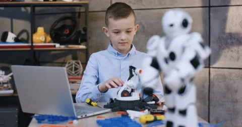 Close up of the blurred white toy robot in front of the camera, and focused teen Video stock 135841118
