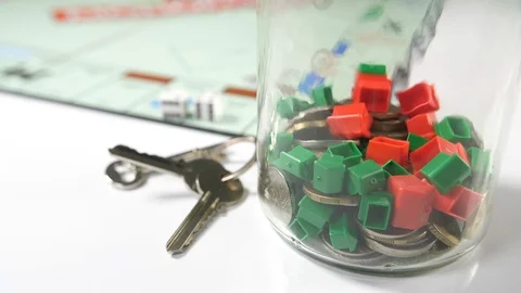 Close up of a board game with dice and a glass jar of coins and red and green Stock Footage 89186539