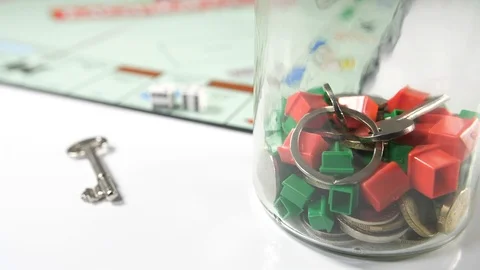 Close up of a board game with a glass jar full of red and green house shaped  Stock Footage 89186487