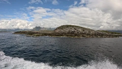 Close boat wake view passing rocky islet in ocean Lofoten 動画素材 344047473