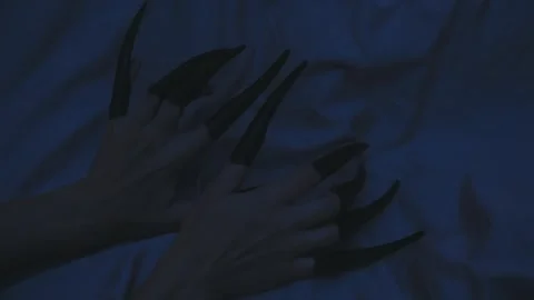 Close-up body part scary ghost hand with long black nails scratching wall Stock Footage 318140165