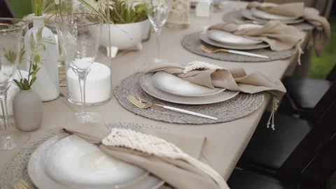 Close-up boho wedding decor, decorated tables served plates with silk napkins Stock Footage 308661301