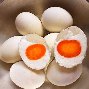 Close-up boiled duck eggs group in A stainless bowl, and cut in half. Stock Photos