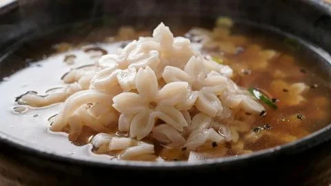 Close-up of boiled sliced lotus root floating in a light savory broth with Stock Photos