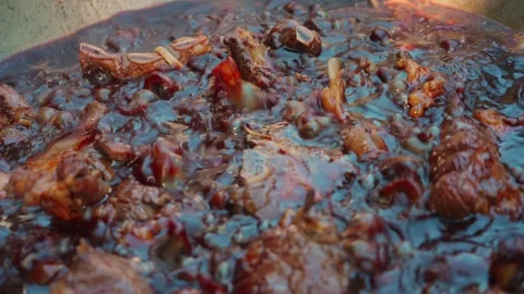 Close-up of boiling broth in an old metal kazan cauldron with oil, meat and Stock Footage 346617873
