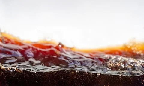 Close-up of boiling hot dark liquid with bubbles and steam Stock Photos