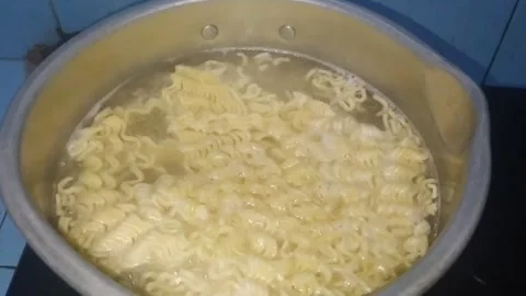 Close up of boiling instant noodles in a stainless steel pan Stock Footage 281143099