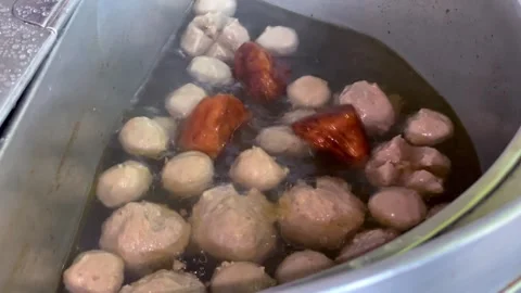 Close up of boiling meatballs and dried tofu in a hot savory soup broth. Stock Footage 323725101