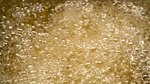 Close-up boiling oil background with potatoes and bubbles, olive oil texture Stock Footage 308774273