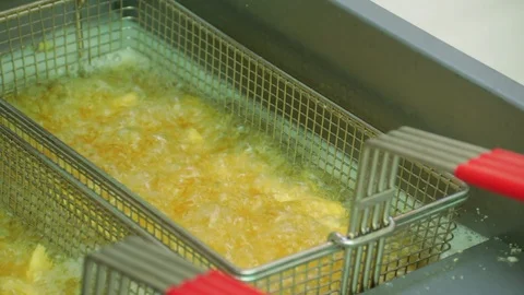 Close up of boiling oil deep frying potato french fries on professional equip Stock Footage 127715533