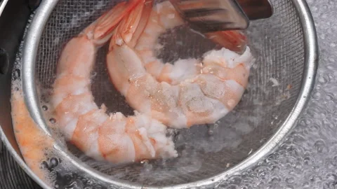 Close up of boiling raw fresh shrimps with a colander in boiling water in a pot. Видео 158667645