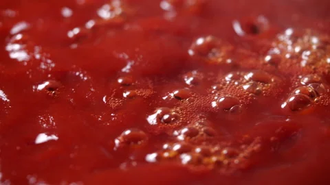 Close-up of boiling red tomato sauce in a pan with steam in 4K Resolution Stockbeeldmateriaal 130931788