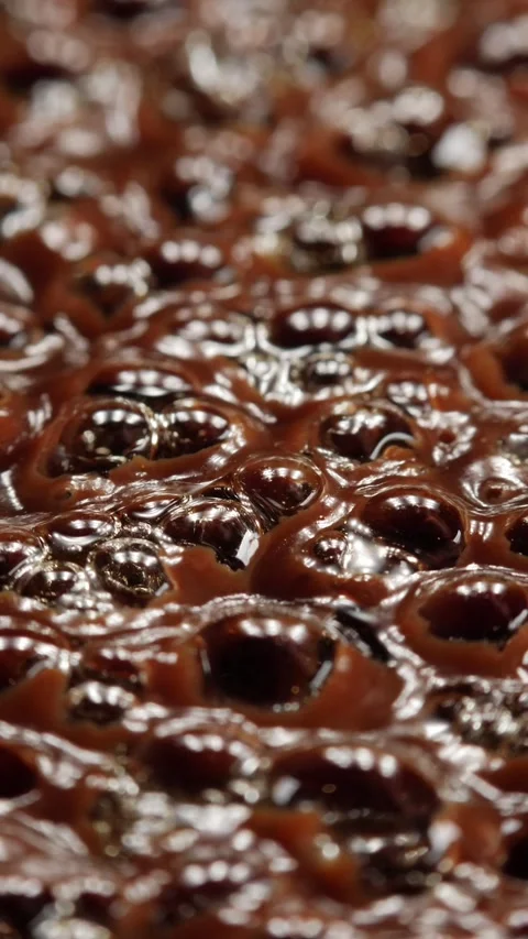 Close-up of boiling thick liquid with bubbling surface. Vertical video. Stock Footage 310371728