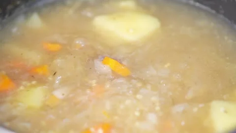 Close-up of boiling vegetable soup with bubbles, potatoes and carrots. 動画素材 345740951