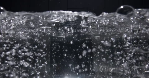 Close-up boiling water in a transparent pan. Boiling water bubbles. Side view Stock Footage 259824180