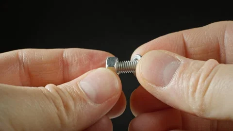 In close-up, a bolt and a nut are twisted by men's hands Stock Footage 265037714