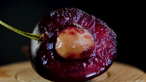 Close-up. Bone and inside of cherry. Cross section of a dark red cherry Stock Footage 202602799