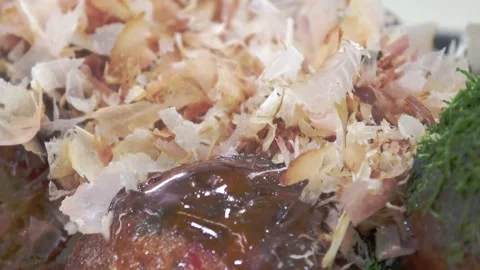 Close-up of bonito flakes dancing on hot takoyaki. Video stock 335736176