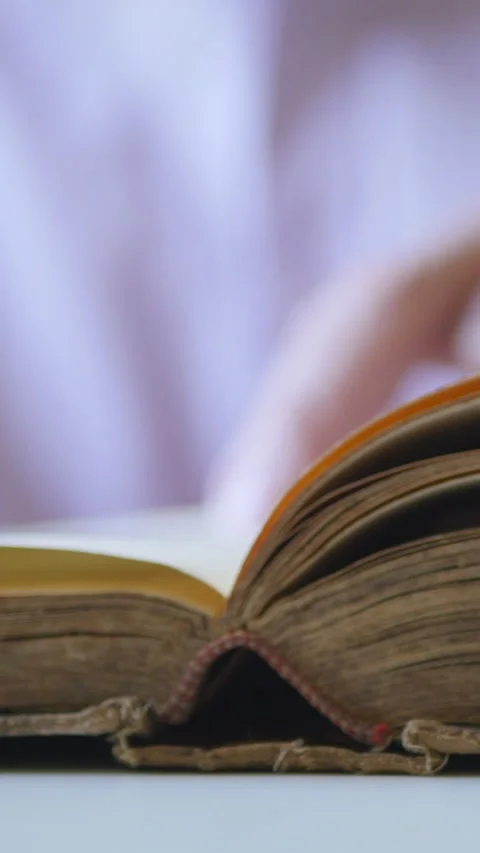 Close-Up Of A Book Being Read And Turned With A Camera Arcing Around Video stock 302540977