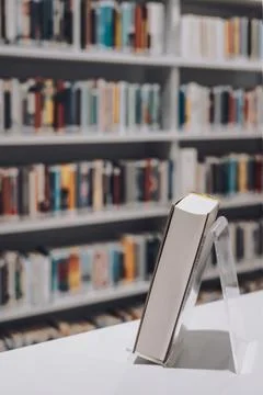 Close-up of a book displayed on a stand with a blurred background of librar.. Stock Photos
