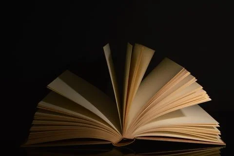 A close up of the book opened over black background Stock Photos