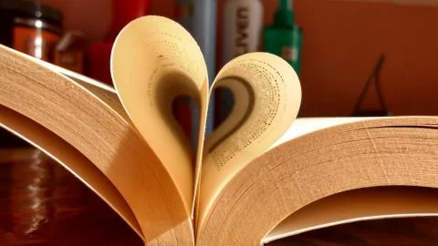 Close-up of the book opened, which the book sheet rolled into a heart shape s Stock Photos