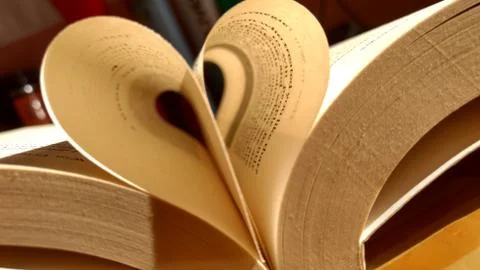 Close-up of the book opened, which the book sheet rolled into a heart shape s Stock Photos