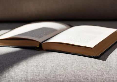 Close up book on sofa, casting shadows Stock Photos