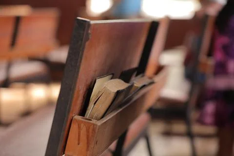 Close up of books for prayers on the back side of a desk in catholic church. Stock Photos