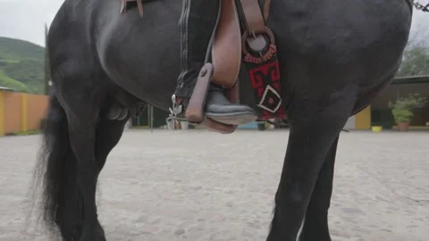 Close up of the boot of a cowboy riding a black horse Stock Footage 159613416