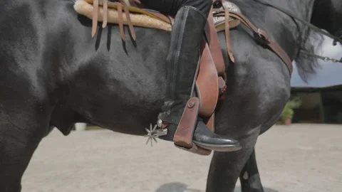 Close up of the boot of a cowboy riding a black horse Stock Footage 159614070