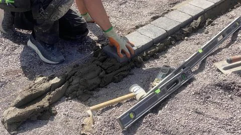 Close-up of boots on edging stones, construction detail during turf groundwor Stock Photos